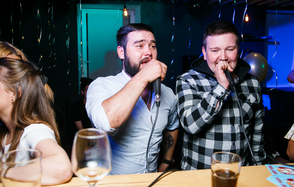 Караоке-бар в центре города. Мужчина и девушка поют в караоке