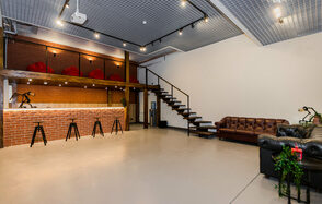 Стильный двухуровневый лофт. Барная стойка. Лестница на второй этаж. Пуфы. Диваны. Барные стулья