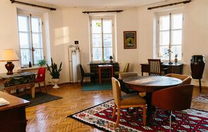 Светлый лофт с панорамным видом. Столы со стульями. Ковры на полу. Различные элементы декора