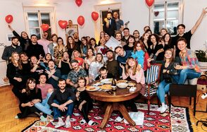 Светлый лофт с панорамным видом. Радостные люди праздную событие и фотографируются