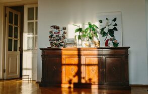 Светлый лофт с панорамным видом. Тумбочка с цветком, книгами, картиной