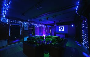 Just Loft на Бауманской. Тёмное освещение. Стол. Диваны. Работающий экран. Гирлянда