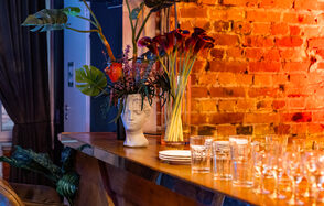 Лофт со сценой. Широкая барная стойка с барными стульями. Стол с едой и посудой