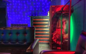 Rave(Рейв). Зона отдыха с черными кожаными диванами, барной стойкой с красными горизонтальными линиями, холодильником Coca-Cola, фоновым освещением в виде синих гирлянд, зелеными и красными световыми акцентами. Стены зелёного оттенка.