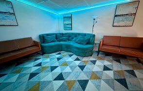 Яркий двухуровневый лофт. Второй этаж лофта. Голубое освещение. Угловой диван. На стенах картины