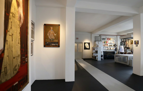 А53: Secret Gallery (Секретная галерея). Галерейное пространство с белыми стенами и черно-белым полом. Картины на стенах. Черный диван и стол в зоне отдыха, стеллажи с книгами справа. Яркое искусственное освещение. Открытая планировка с видимой мебелью и декором.