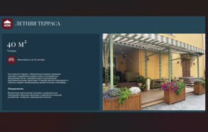 Особняк на Пятницкой (Пространство для банкетов). Летняя терраса с бежевыми стенами и металлическим навесом. Садовая мебель, крупные деревянные кашпо с цветами. Лампочки на светодиодных гирляндах. Деревянный настил, серые плитки на полу. Широкий вход, жёлто-оранжевое ограждение.