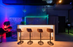 Неоновый лофт-зал с барной стойкой и сценой