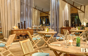 Soho Country Club (Сохо Кантри Клаб). Зал с деревянными столами и складными стульями с подушками. Деревянные комоды, декоративные статуи. Пол—дерево, стены декорированы тканевыми занавесками. Теплое освещение, расставлены свечи и бокалы.