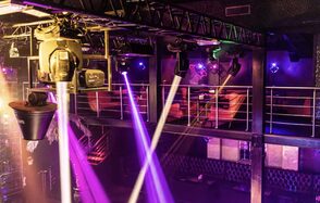 Castle Concert Hall(Концертный зал Замок). Многоуровневое пространство для мероприятий, с металлическими перилами и сидячими местами на втором этаже. Световое оборудование, разноцветные прожекторы и лучи. Декор в тёмных тонах, кожаная мебель. Индустриальные элементы в дизайне.