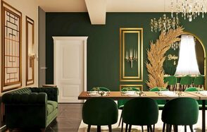 Голливуд. Элегантный лофт в зелено-бежевых оттенках. Зал с темно-зелеными стенами и белым потолком, длинный деревянный стол с зелеными стульями, рядом темно-зеленый диван. На стене декоративные элементы золотого цвета, светильник, золотистая композиция. Потолок украшен светильником-кристаллом.