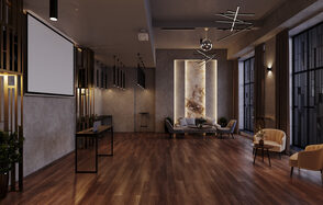 Лофт Мираж. Просторное помещение с паркетным полом и серыми стенами. На стене большой экран для проекций. Современные светильники подвешены к потолку. В углу мягкие кресла и диван. На потолке установлен проектор. Разные источники настенного освещения.