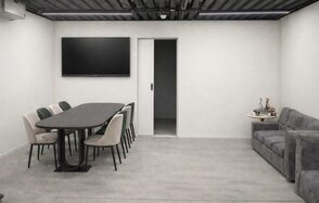 Level 5(Лэвел 5). Современное помещение для встреч с большим овальным столом, окружённым стульями, серый диван, телевизор на стене, торшер и небольшой столик с декором. Серые стены и потолок с индустриальным дизайном.