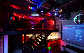 Soul Loft . Затемнённая комната лофта, много людей в кадре проводят фуршетное мероприятие, беря еду с объединённых столов. Несколько людей на кадре танцуют