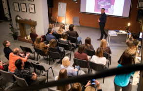 Стильный двухуровневый лофт. Парень играет в "бирпонг". На втором плане общаются люди