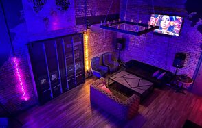 Контраст Loft. Приглушённый свет. неоновая подсветка. Барная стойка с барными стульями. Кресла. Картина на стене. Декоративные свисающие лампы